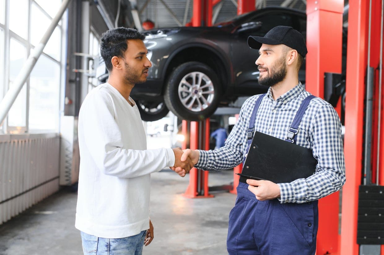 Two people discussing a vehicle inspection at a workshop