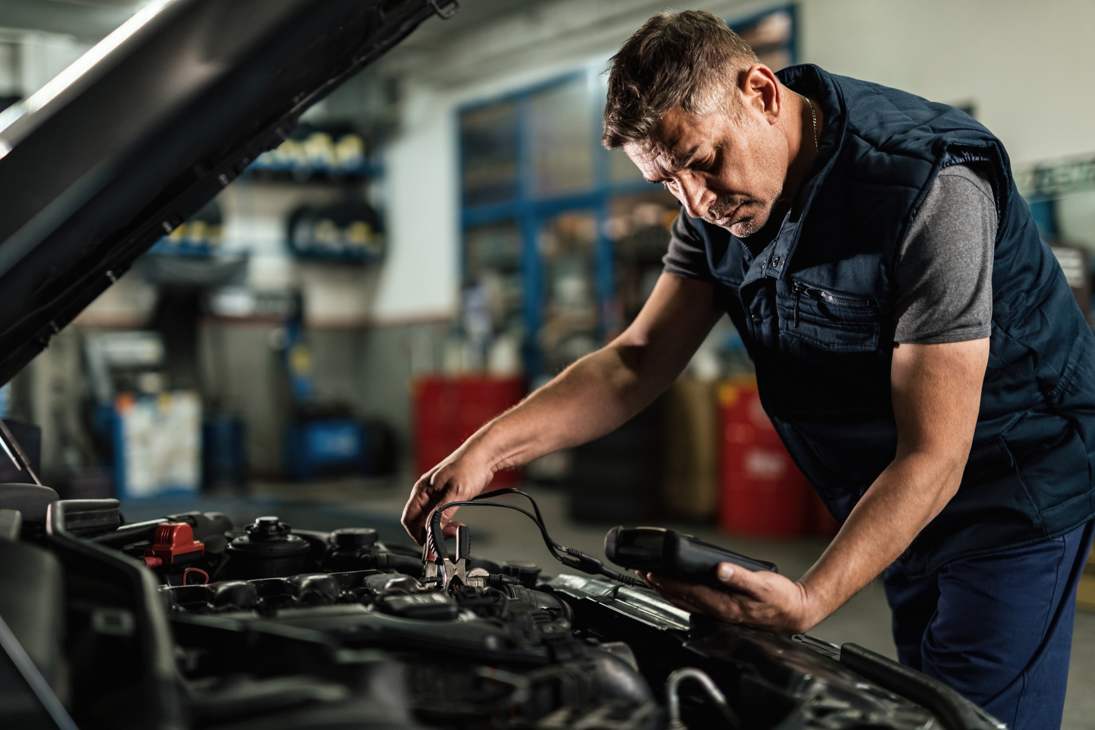 A licensed mechanic running a diagnostic check on a car engine